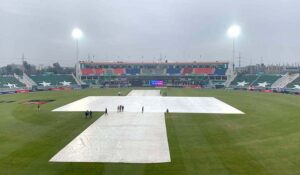 Ground staff swiftly cover the field during a downpour to safeguard the pitch as rain delays the ICC Champions Trophy clash between Australia and South Africa at Rawalpindi Cricket Stadium.
