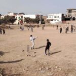 Youngsters are playing cricket in the local ground at Qasim Park
