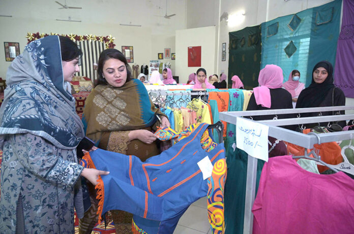 Women explore a fabric stall to purchase a beautiful outfit for them at the Exhibition of Govt. College of Technology for Women, Sargodha