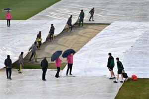 Ground staff swiftly cover the field during a downpour to safeguard the pitch as rain delays the ICC Champions Trophy clash between Australia and South Africa at Rawalpindi Cricket Stadium.