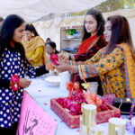 Female students purchasing the flower bracelet from the stall during the spring festival at La Salle Higher Secondary School