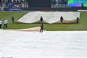 Ground staff swiftly cover the field during a downpour to safeguard the pitch as rain delays the ICC Champions Trophy clash between Australia and South Africa at Rawalpindi Cricket Stadium.