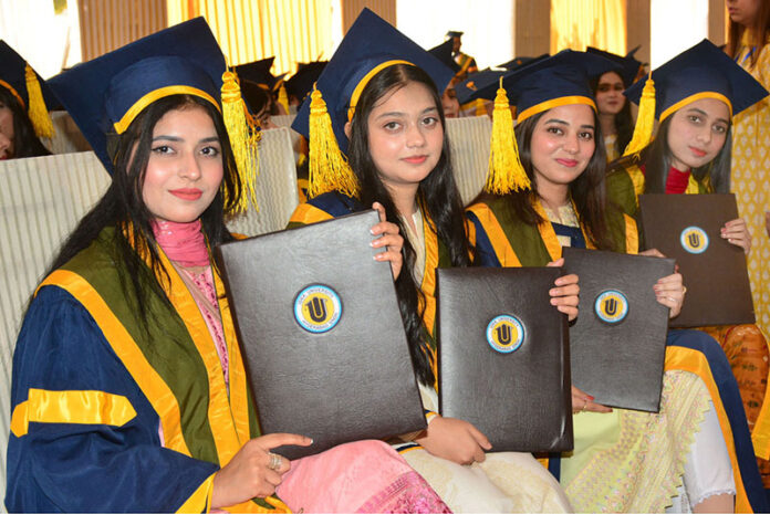 Successful graduate students showing their degrees during 22nd convocation of ISRA University