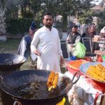 A vendor fries crispy potato spring chips for customers at his roadside stall in the city