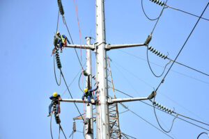 WAPDA workers busy installing new electricity wires on an electricity pole at Davis Road.