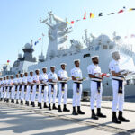 Pakistani Navy personnel carry the flags of participating foreign countries during the flag-hoisting ceremony of AMAN 2025 in provincial capital