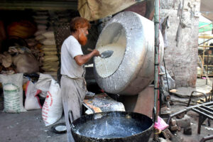 Worker busy making sweet item (makhana) from sugar to attract customers