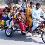 A gypsy family traveling on tricycle cart at Mohenjo-Daro Airport Road