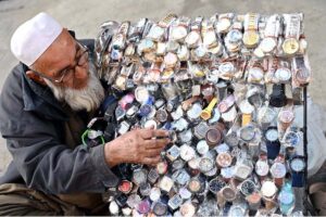 An old vendor displaying watches to attract customers at Pakistan Chowk.