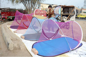 A roadside vendor displays mosquito nets for protection against dengue fever, attracting customers ahead of seasonal demand.