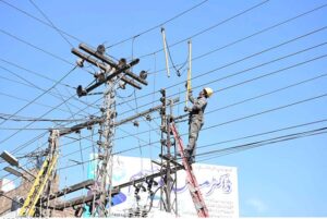 A FESCO worker of city-subdivision fixing the electric line near Karkhana bazaar.