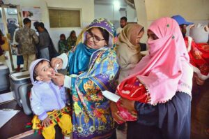 Lady Health worker busy in administering polio drop to child during national anti-polio campaign at Bhitai Hospital.
