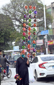 A vendor displaying handmade toys for children to attract the customers in a local market.