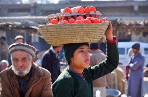 A young vendor displays and sells boiled eggs to attract passersby as the temperature drops near the Fruit Market.