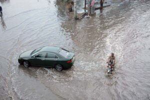 Vehicles passing through rain water accumulated on Jhumra road near Nishatabad after heavy rain in the city.