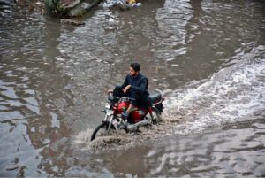 Vehicles passing through rain water accumulated on Jhumra road near Nishatabad after heavy rain in the city.