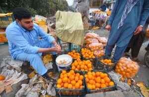 Vendor was busy in washing oranges before selling at Haji Camp GT road.