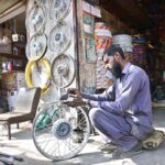 A mechanic busy in polishes a motorcycle wheel rim at his workshop