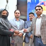 Chairman Pakistan Surgical Association Zeeshan Tariq Sheikh distributes cheques among workers during a Labour Department cheque distribution ceremony at SIMAP