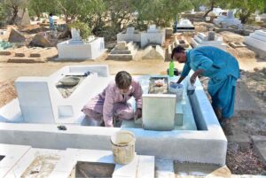 People busy in repair and paint the graves of their relatives at Tando Yousuf Graveyard in connection with Shab-e-Barat