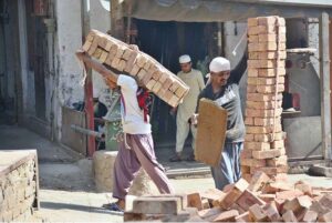 Labourers busy in shifting the bricks for construction work of home at Fort Road area