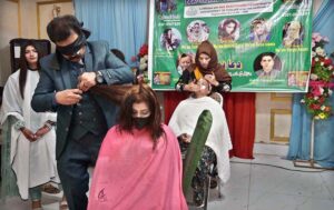 A makeup artist demonstrates expert techniques to train students during a workshop at an event organized by the Mashallah Beautification College of Art.
