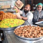 A halwai seller sells sweets in Gwalmandi Bazaar on the occasion of Shab Barat