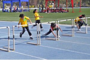 Students participate in an athletic race with hurdles during the annual sports day of Foundation Public School at the Sports Complex.