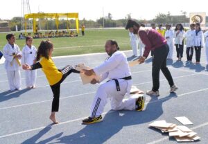 Students participate in an athletic race with hurdles during the annual sports day of Foundation Public School at the Sports Complex.