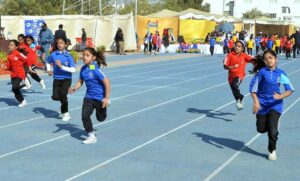 Students participate in an athletic race with hurdles during the annual sports day of Foundation Public School at the Sports Complex.