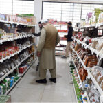 People purchasing grocery items from store at G-7 market