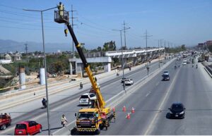 A worker repairs a street light while standing on a crane at IJP Road in the Federal Capital.