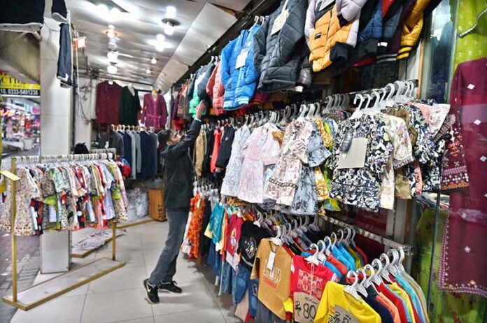 A vendor displaying garments on his shop to attract customers at Aabpara in the Federal Capital