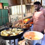 A vendor busy frying traditional food item (Kachori) for iftar near G-7 area in the Federal Capital