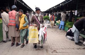 An elderly disabled man sells shopping bags to attract customers at the weekly bazaar in H-9 sector, Federal Capital.