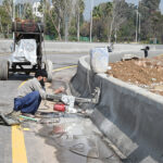 Laborer busy construction work of boundary wall near of roadside greenbelt in the Federal Capital