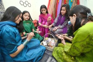 Girls are showing off their hands after applying mehndi designs in preparation for the upcoming Eid ul-Fitr