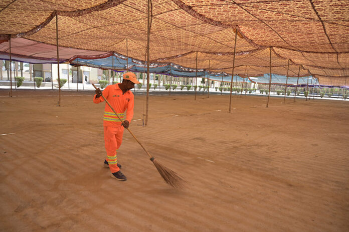 A worker is busy cleaning the Eidgah in preparation for Eid-ul-Fitr prayer