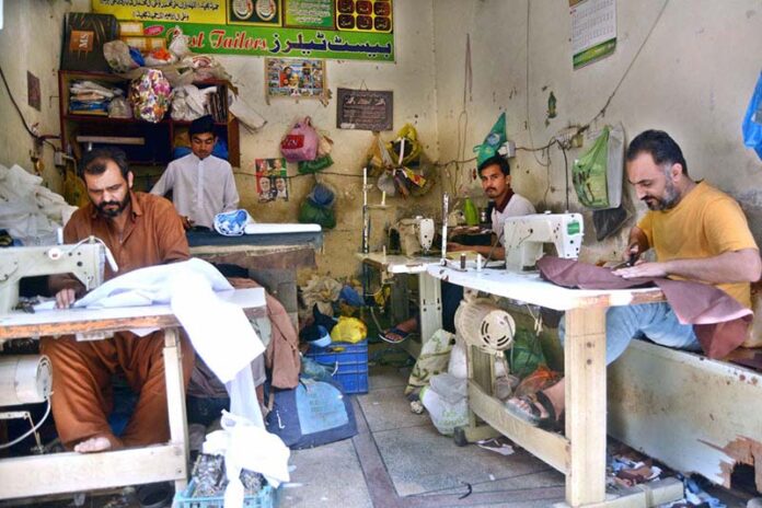 Tailors work tirelessly, stitching clothes to meet the high demand ahead of the upcoming Eid ul Fitr festival