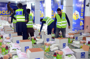 Volunteers of Al-Khidmat foundation packing the Ramzan gift items before distribution different areas to deserving people at Tabligh-e-markaz Makki Shah
