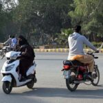 A woman on the way traveling on her scooty at college road