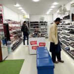 A man selects shoes at a shop in Aabpara, Federal Capital