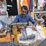 A worker busy in embroidery work on clothes at his workplace for customers as people starts preparation for the upcoming Eidul Fitr celebrations