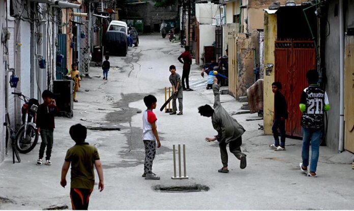 Youngsters playing cricket in a street at G-6 area in the Federal Capital