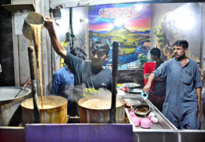 A tea vendor prepares tea for customers after Iftar at a local hotel, a common sight during the holy month of Ramadan.