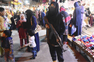 Lady police constable standing high alert during Women busy shopping in preparation for the upcoming Eid-ul-Fitr at Resham Gali Bazaar.