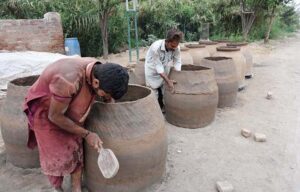 Workers busy making a traditional oven (tandoor) at Railway Road