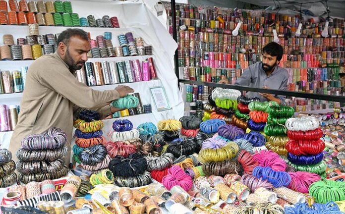 Vendors are busy arranging and displaying bangles to attract the customers at Jinnah Super Market in the Federal Capital in connection with upcoming Eidul Fitr