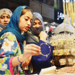 A girl selecting and purchasing artificial jewelry from stall for preparation of upcoming Eid-ul-Fitr in a local market