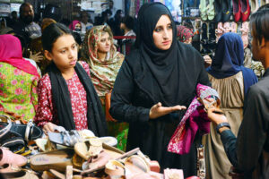A girl selecting and purchasing artificial jewelry from stall for preparation of upcoming Eid-ul-Fitr in a local market
